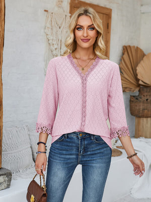 Blush pink eyelet blouse with V-neck and lace trim on neckline and sleeves.