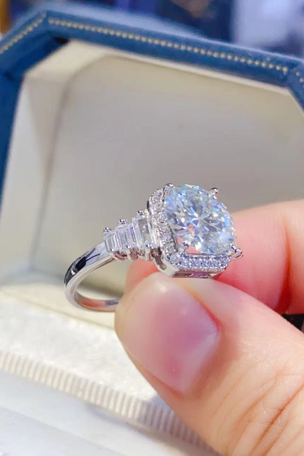 Silver ring with cushion cut moissanite and baguette accents.