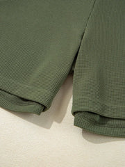 Moss green waffle knit romper detail showing hem and side slit