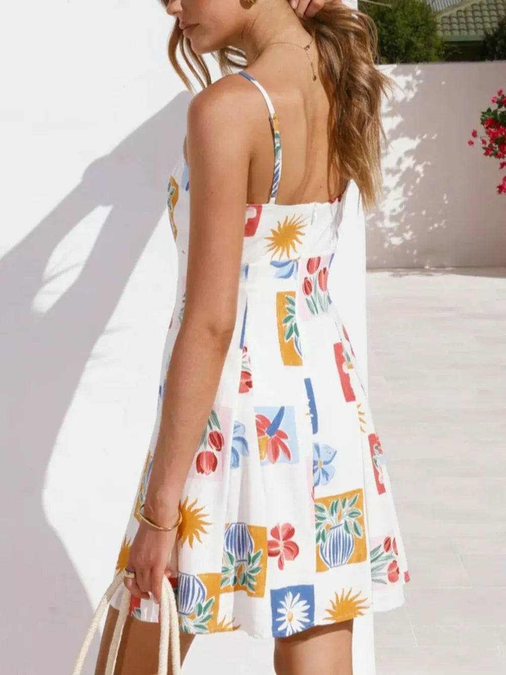 Vibrant floral print mini dress with tie-front detail, A-line cut, and spaghetti straps.