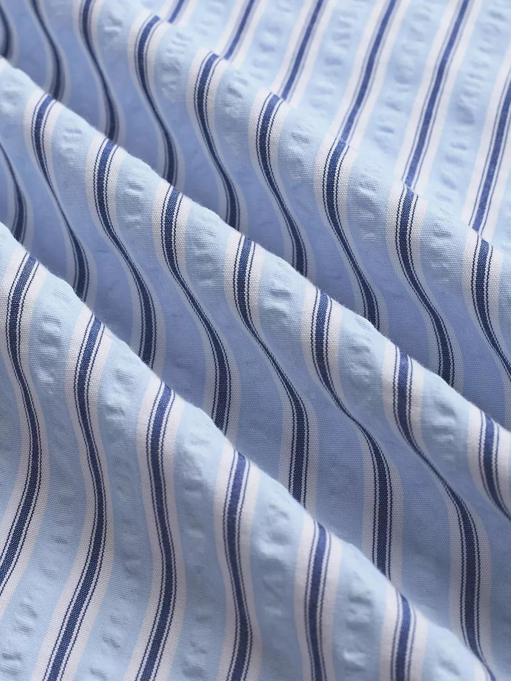 Maternity pants with blue and white vertical stripes and textured fabric detail.