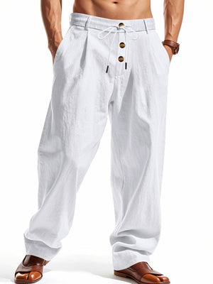 Men's white loose fit drawstring pants with button detail and pleats.