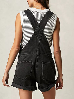 Black denim short overalls with rolled hems and a striped tank top.