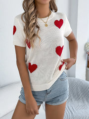 White knit sweater with red heart motif, short sleeves, crew neck.