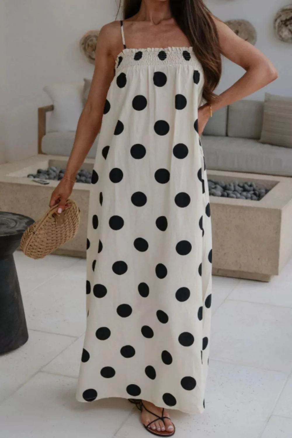 Cream polka dot maxi dress with smocked bodice and spaghetti straps.