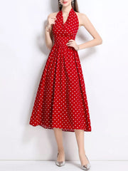 Red polka dot halter midi dress with a pleated skirt.