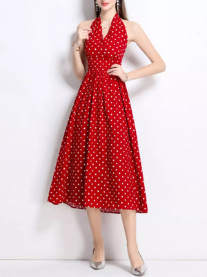 Red polka dot halter midi dress with a pleated skirt.