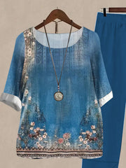 Floral print half sleeve top and solid pants set in Peacock Blue, with a round neckline and white cuffs.