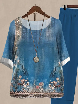 Floral print half sleeve top and solid pants set in Peacock Blue, with a round neckline and white cuffs.