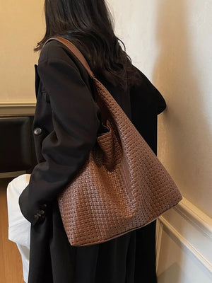 Brown woven straw texture tote bag with leather strap.