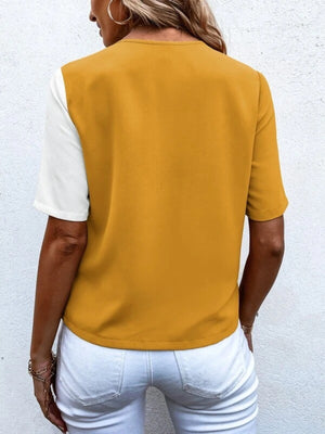 Two-tone mustard and white short sleeve shirt with asymmetric color block detail.