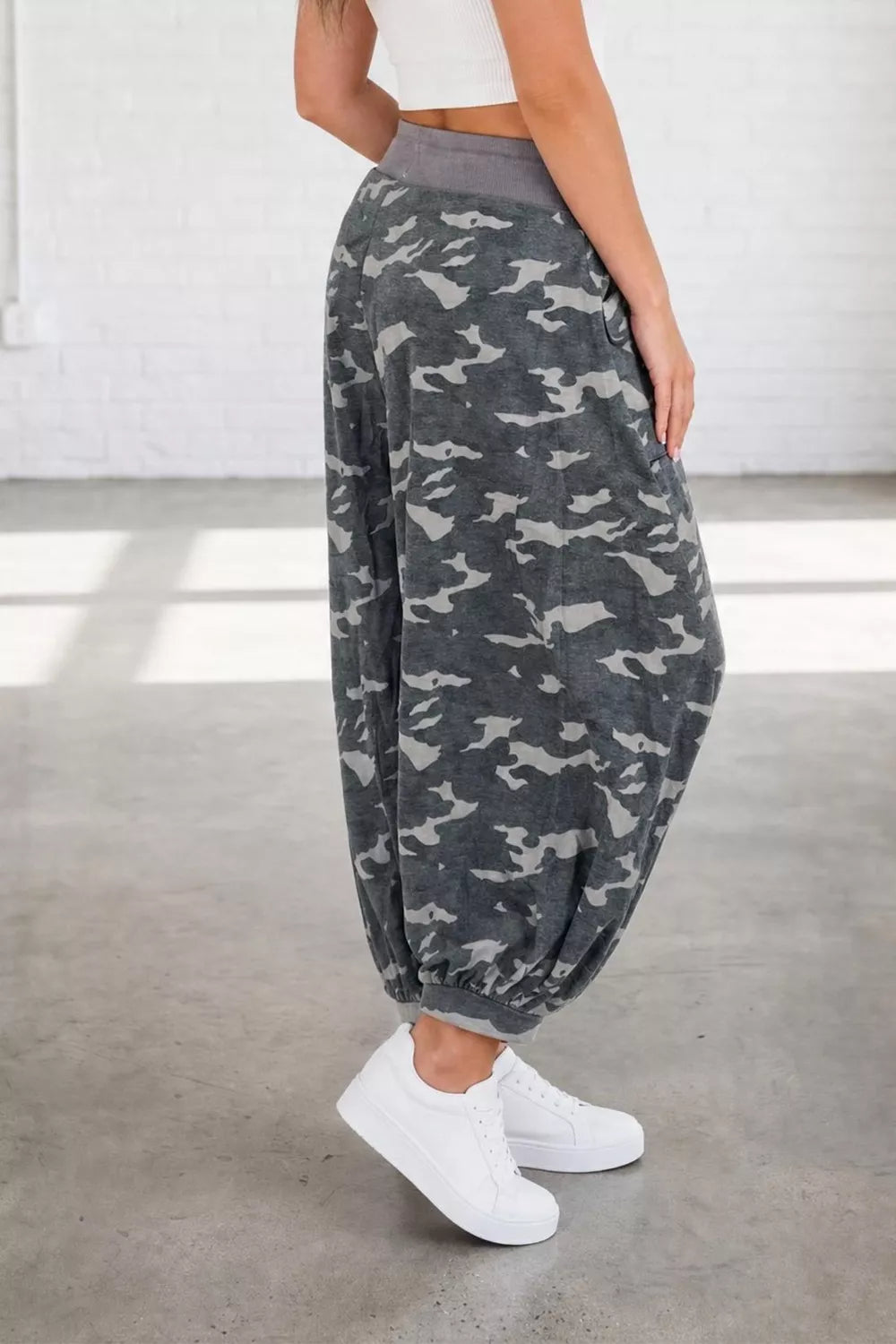 Camouflage barrel pants with cargo pockets and elastic cuffs, styled with white sneakers.