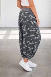 Camouflage barrel pants with cargo pockets and elastic cuffs, styled with white sneakers.
