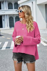 Hot Pink acrylic sweater with flared sleeves and slit hem detail.