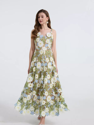 Maxi dress with floral embroidery and appliqué, featuring a green brocade base with white and blue flowers.