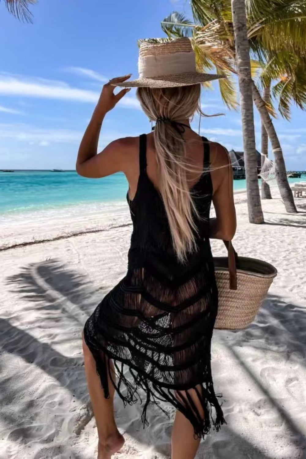 Black macramé chevron cover-up dress with fringe hem, styled with a straw hat and beach bag.