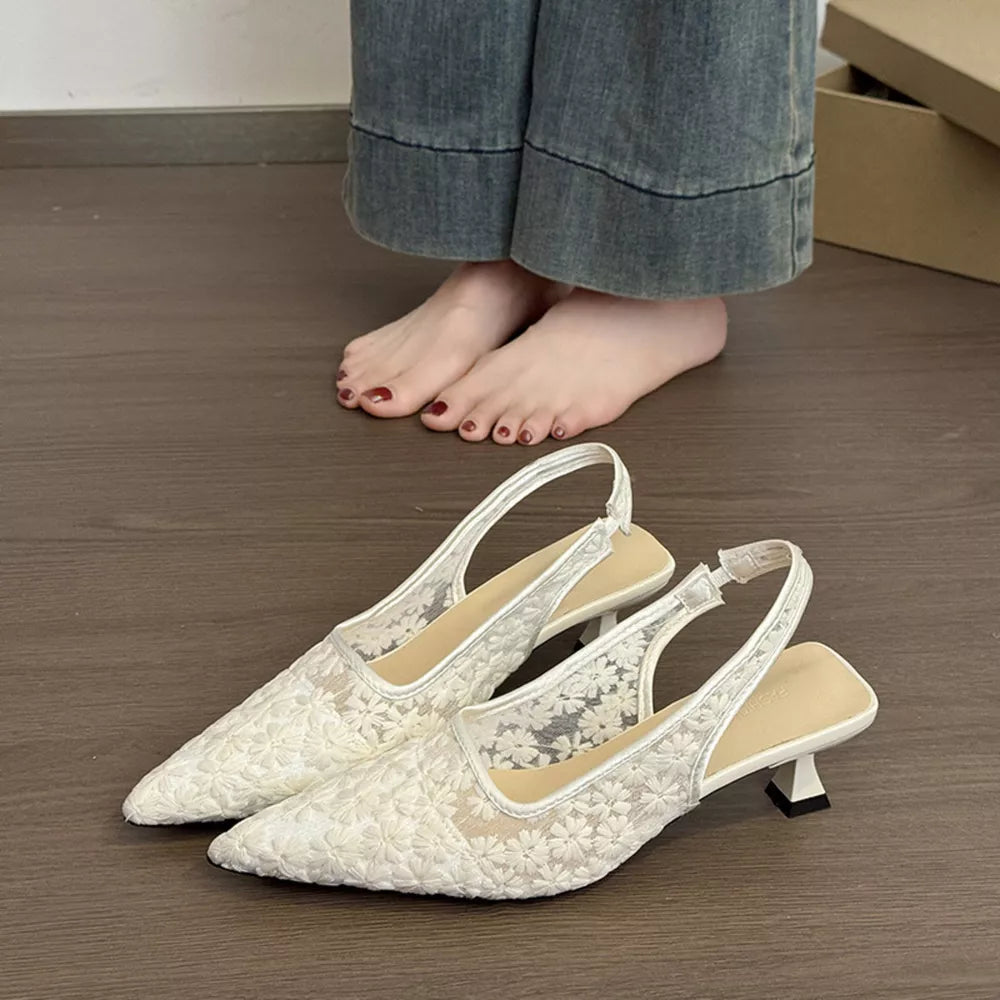 Elegant white lace slingback kitten heels with floral pattern and kitten heel.