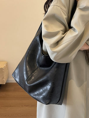 Black faux leather slouchy shoulder bag with adjustable strap detail
