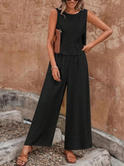 Black ruffled peplum top and wide-leg pants set with round neckline and sleeveless design.