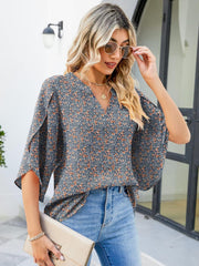 Floral print V-neck blouse with flutter sleeves and 100% polyester fabric.