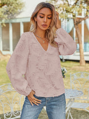 Blush pink textured puff sleeve V-neck blouse with all-over feather-like pattern.