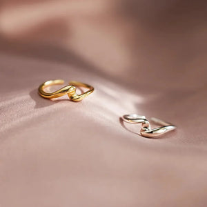 Gold two-tone intertwined open ring with a wavy design.