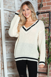 White ribbed knit V-neck sweater with pearl trim and black stripes.