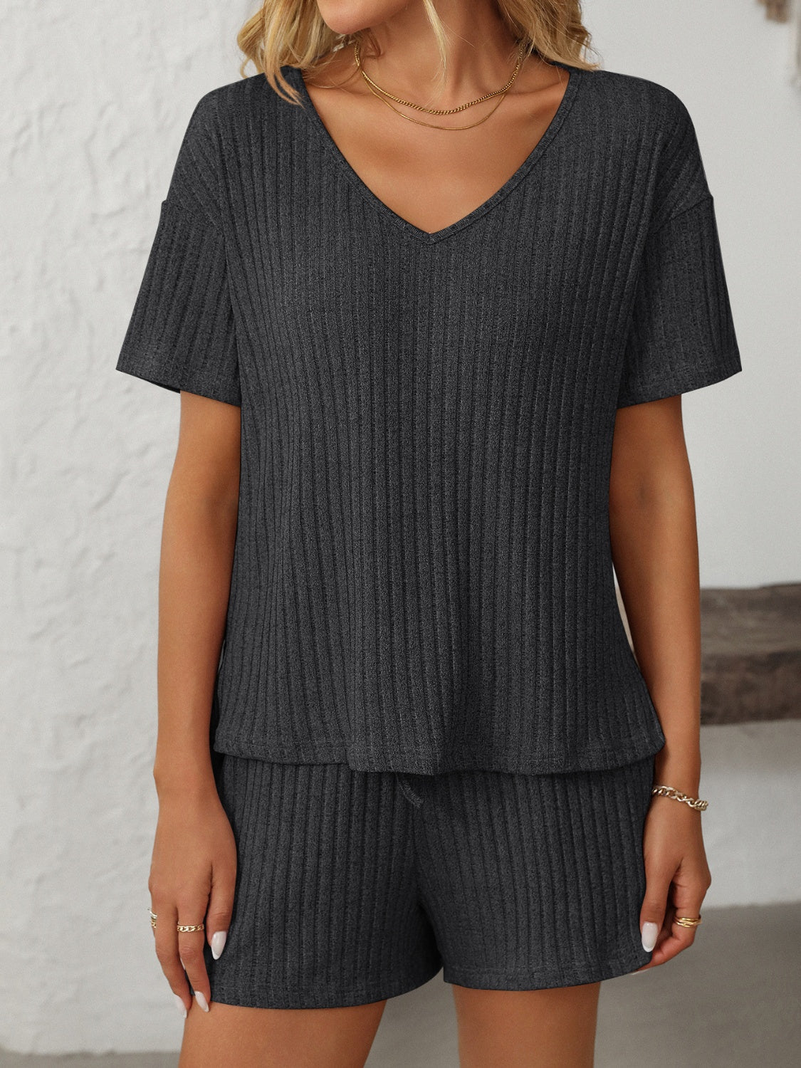 Black ribbed V-neck loungewear set with short sleeves and drawstring shorts.