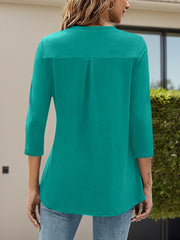 Teal three-quarter sleeve top with a V-neck and back pleat detail.