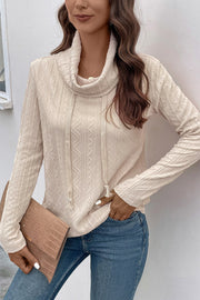 Beige textured cowl neck knit sweater with drawstring detail and long sleeves.