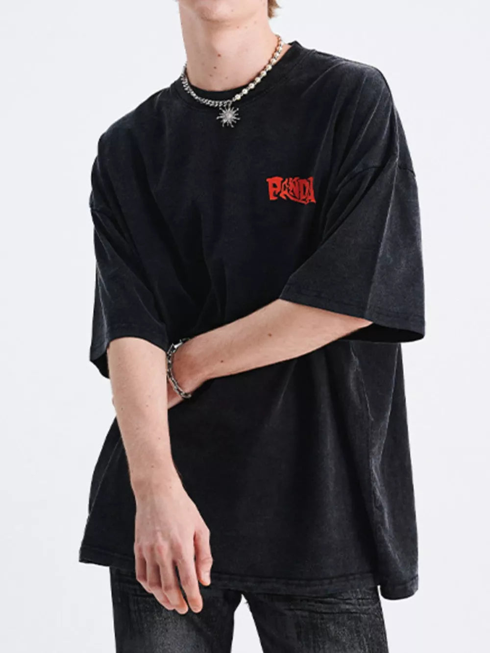 Black relaxed fit graphic t-shirt with red chest logo and crew neck.