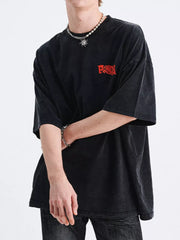 Black relaxed fit graphic t-shirt with red chest logo and crew neck.