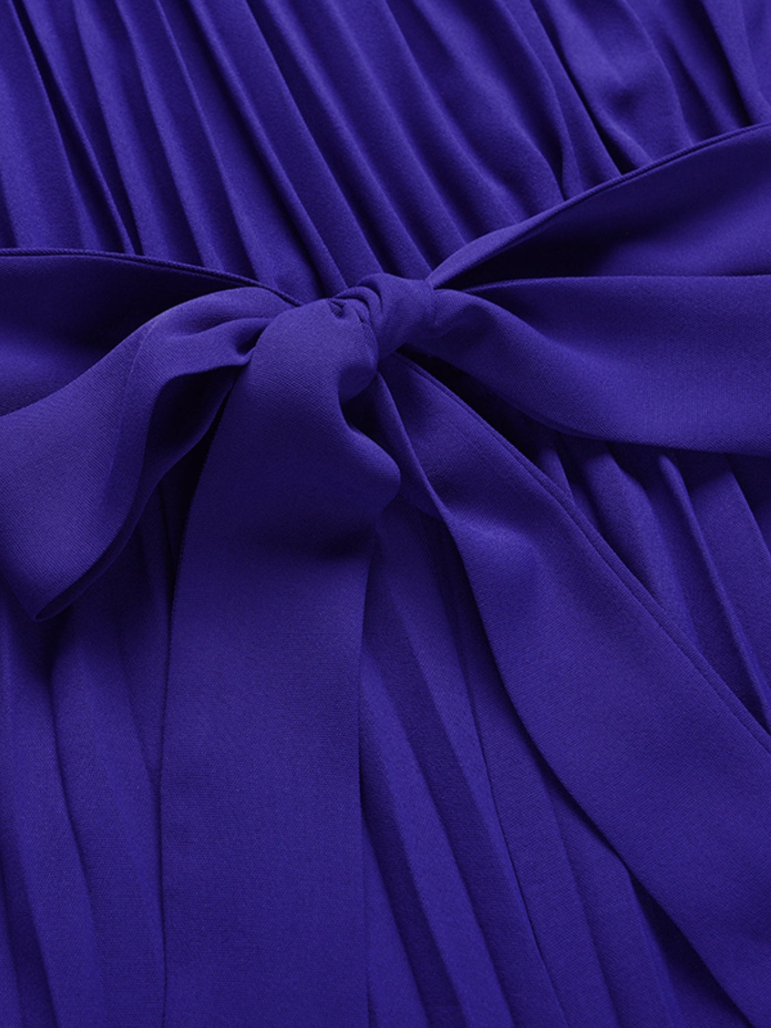 Dark blue halter neckline pleated palazzo jumpsuit with a tie waist detail.