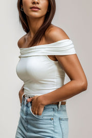 White off-the-shoulder sculpted bodice top with draped neckline detail.