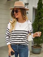 White and black striped acrylic sweater with shoulder buttons.