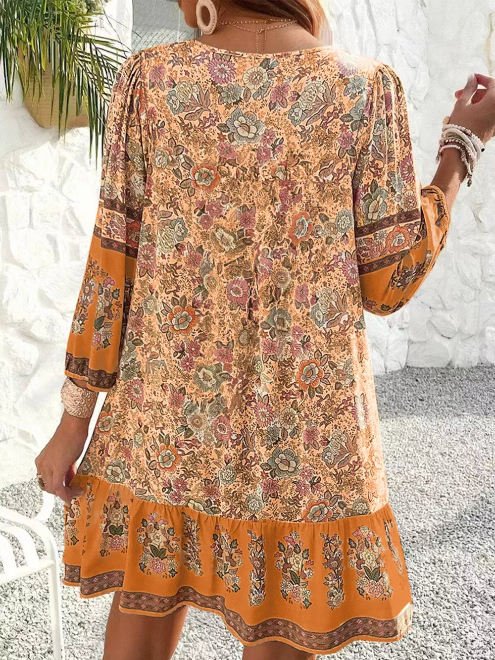Ochre floral print mini dress with tiered hem and ruffled sleeves.