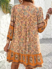 Ochre floral print mini dress with tiered hem and ruffled sleeves.
