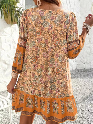 Ochre floral print mini dress with tiered hem and ruffled sleeves.
