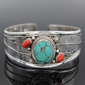 Turquoise and coral feather cuff bracelet in silver with intricate detailing.