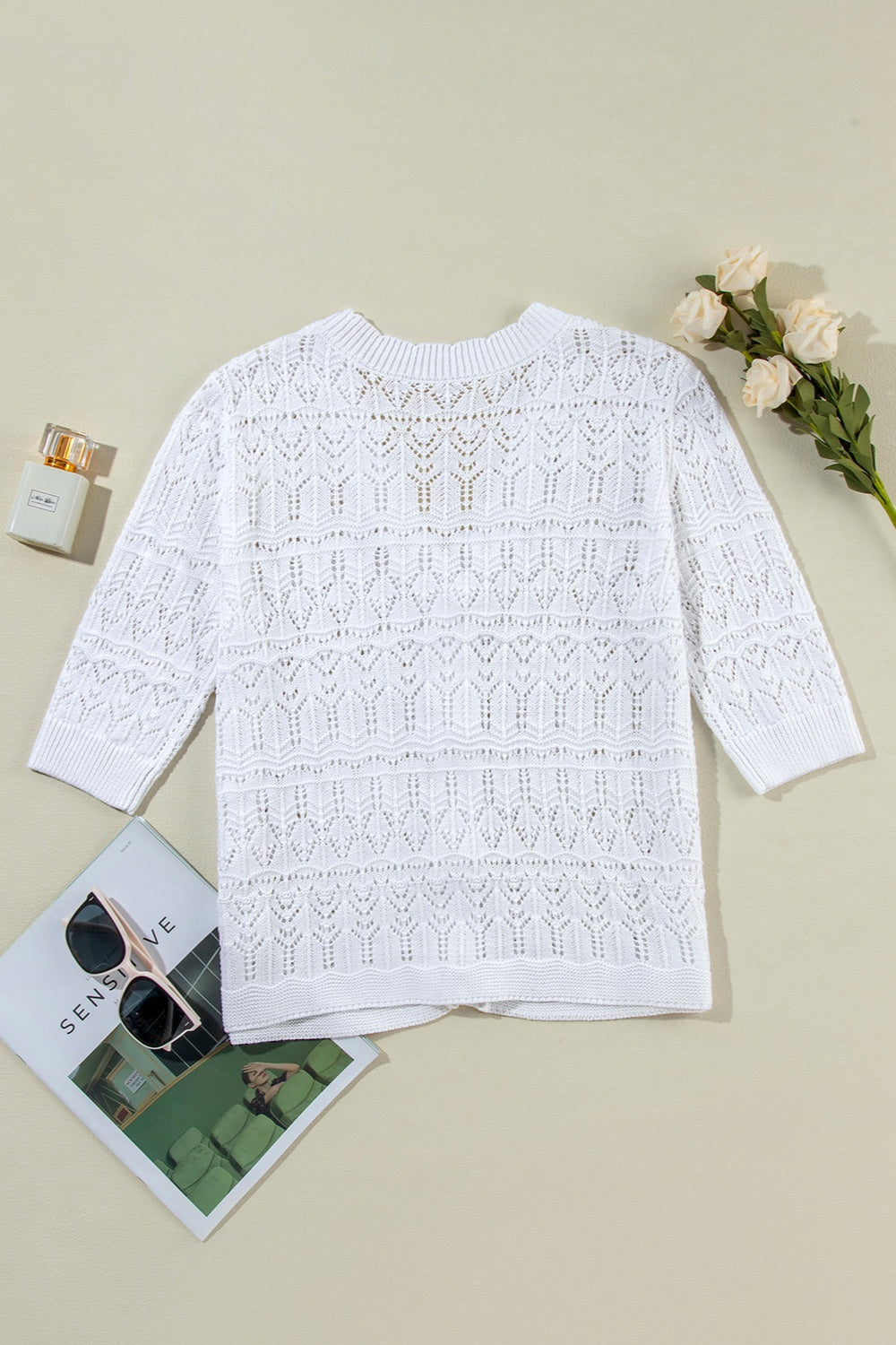 White openwork crochet cardigan with 3/4 sleeves and a relaxed fit.