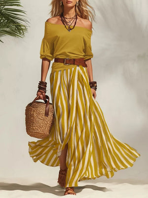 Yellow off-shoulder top and striped maxi skirt set with a brown belt.