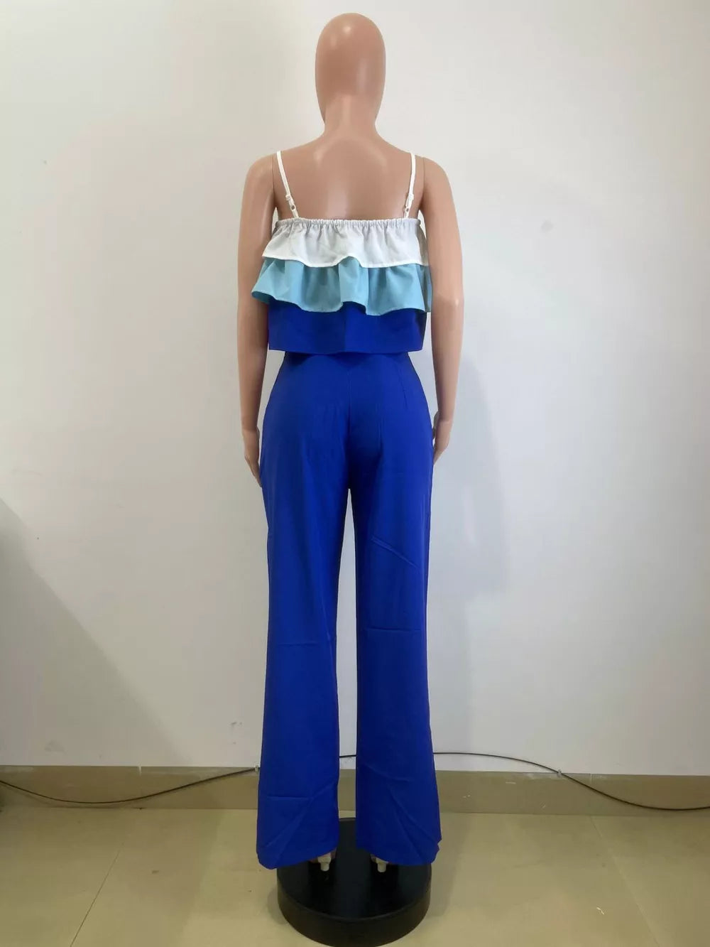 Chic layered ruffle crop top set with blue wide-leg pants.