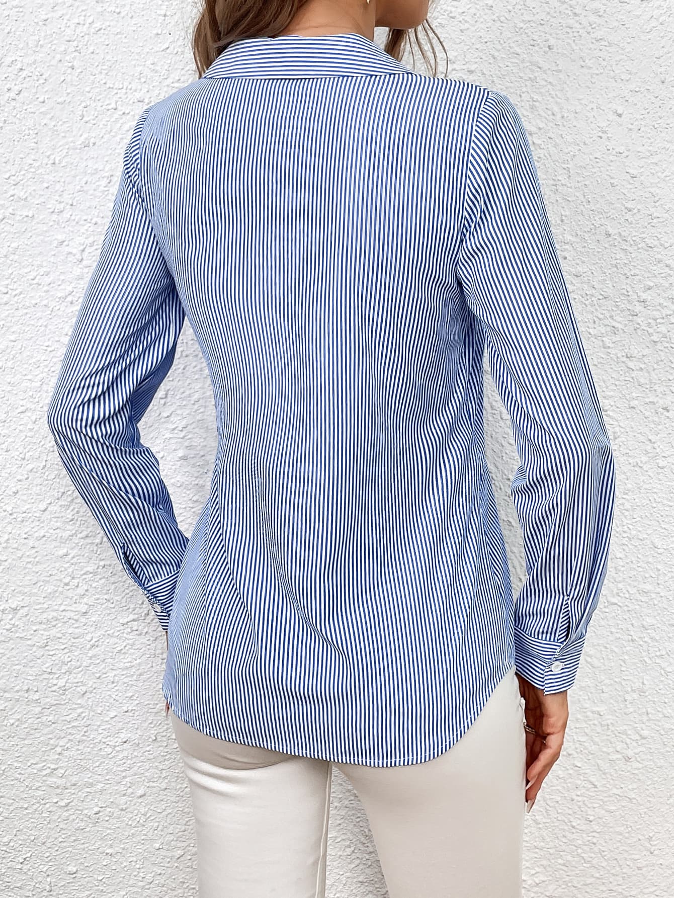 Sky blue and white striped wrap-front blouse with bow detail.