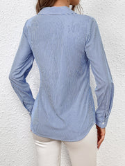 Sky blue and white striped wrap-front blouse with bow detail.