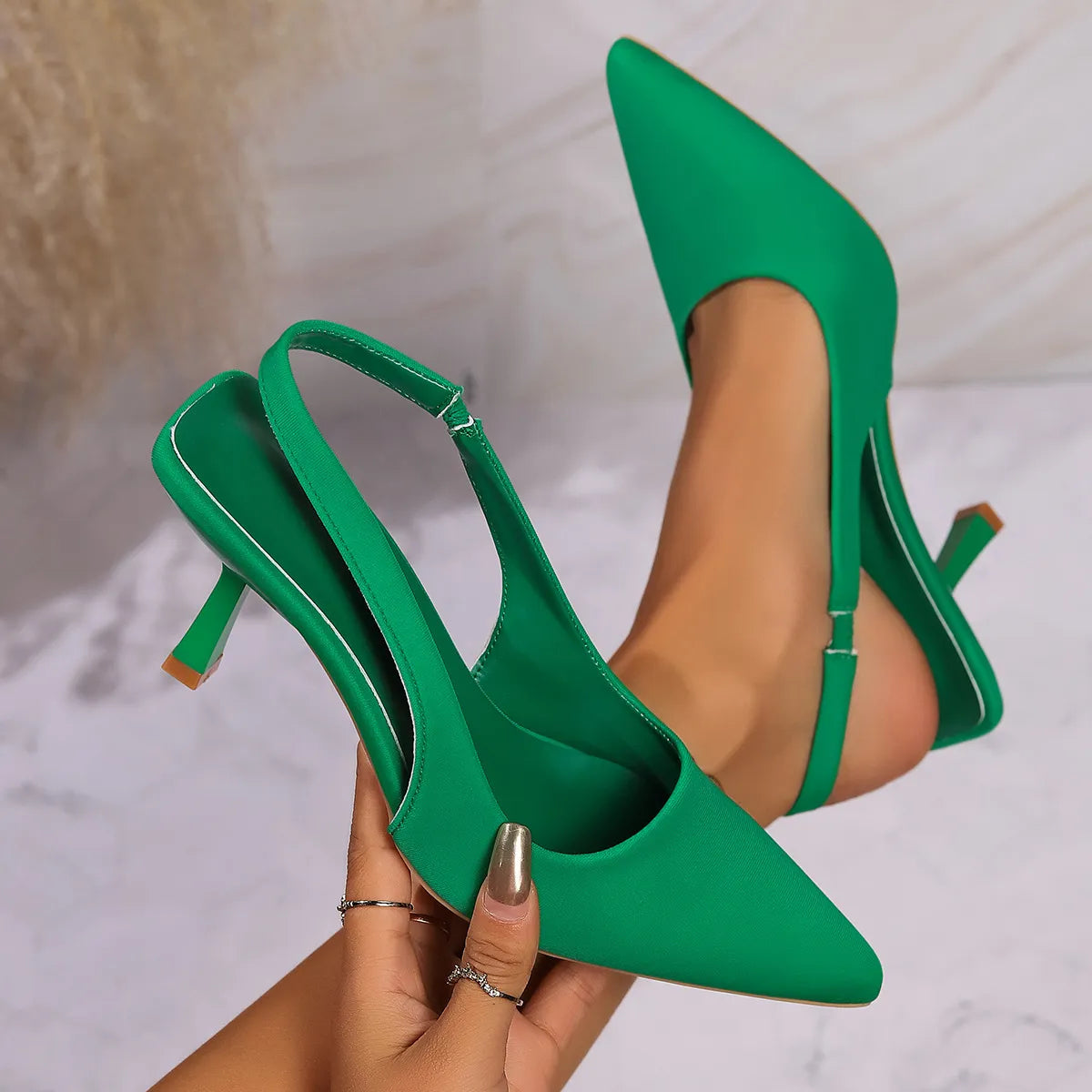 Green slingback pointed kitten heels with a thin ankle strap.