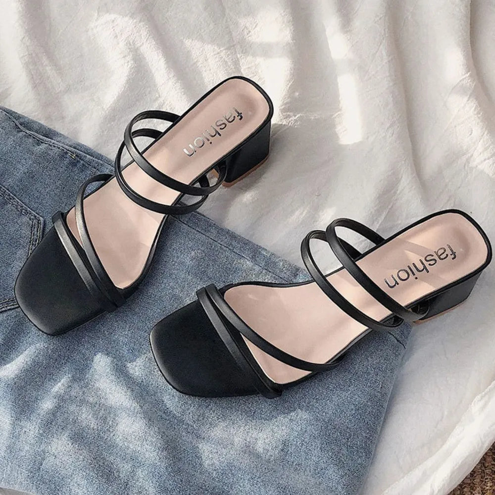 Black strappy minimalist block heel mules with square toe and "fashion" detail on insole.