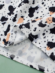 White blouse with black, grey, and peach terrazzo print and ruffle yoke detail.