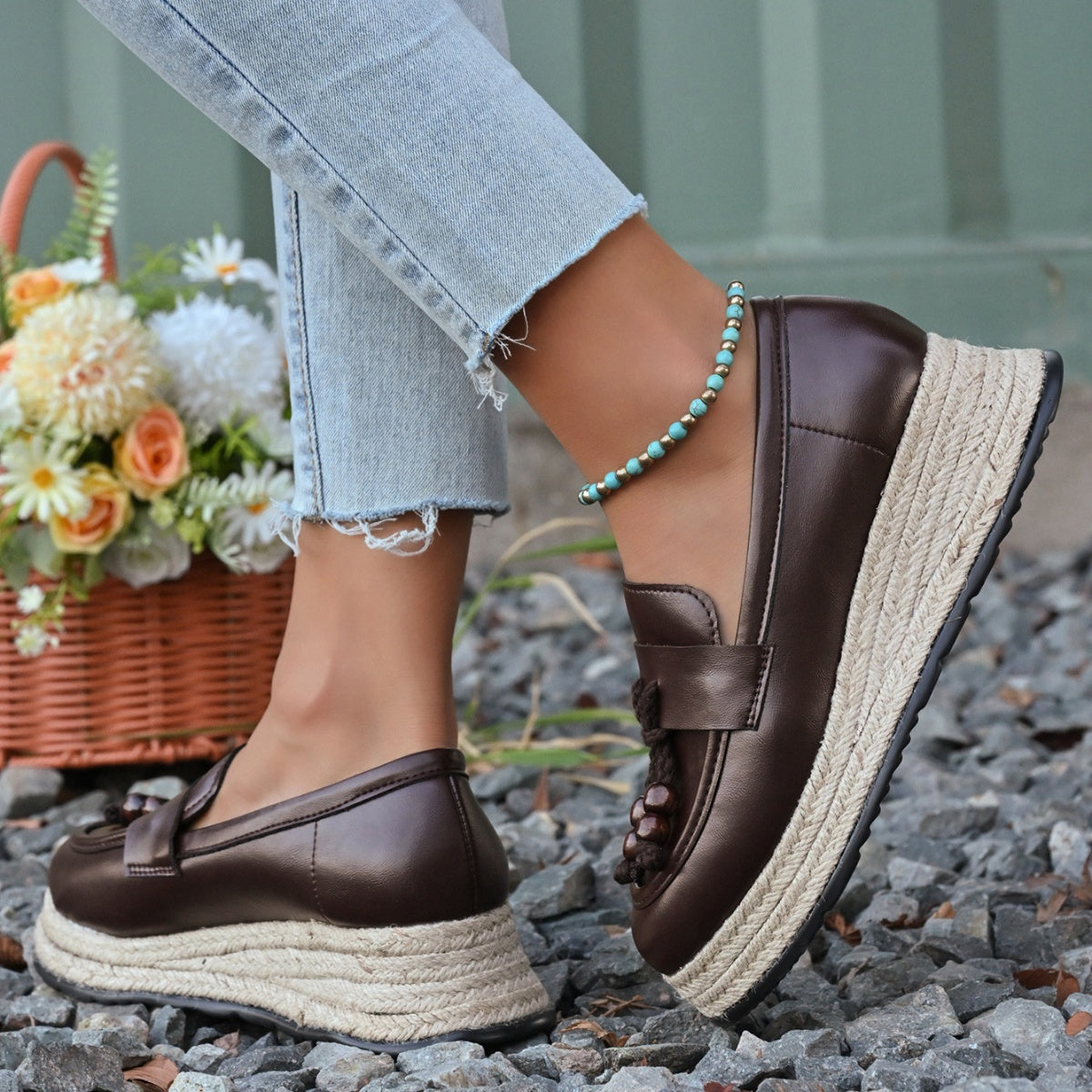 Brown espadrille wedge slip-on loafers with braided jute sole and tassel detail.