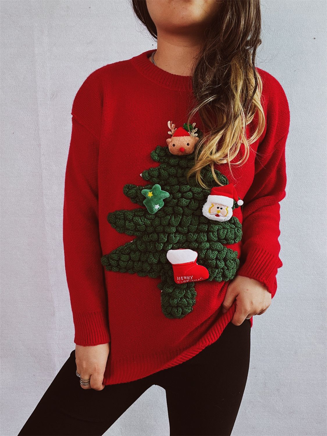 Red acrylic knit sweater with a 3D Christmas tree applique, Santa, reindeer, star, and stocking.