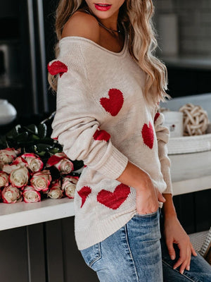 Eggshell knit sweater with red heart motif, long sleeves, and off-the-shoulder neckline.